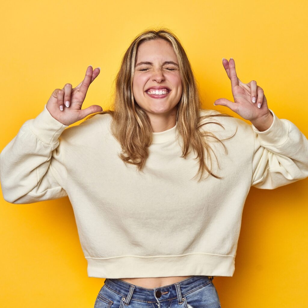 junges Mädchen kreuzt hoffnungsvoll Finger